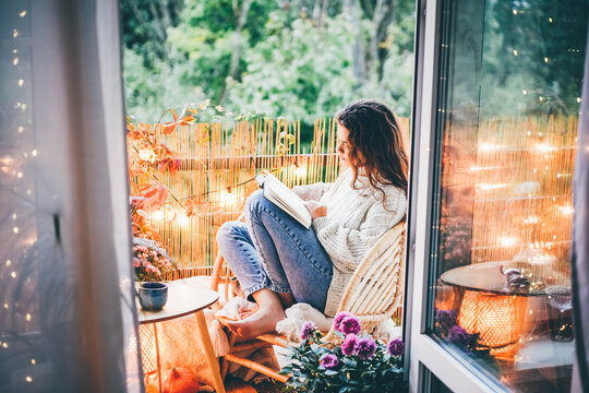 女人在舒适的阳台上放松，看书。