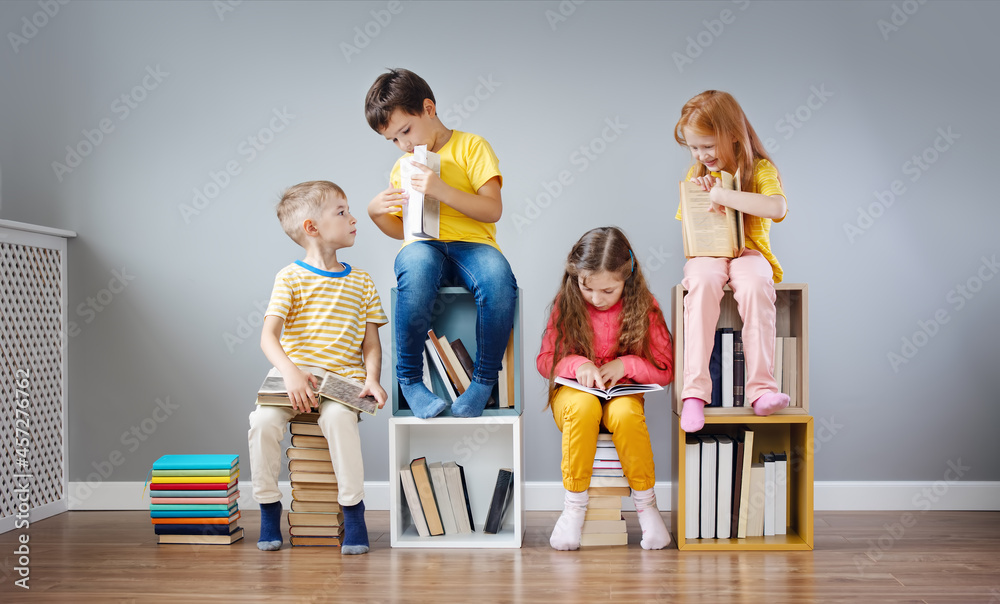 一群孩子坐在房间里的书堆和书架上阅读