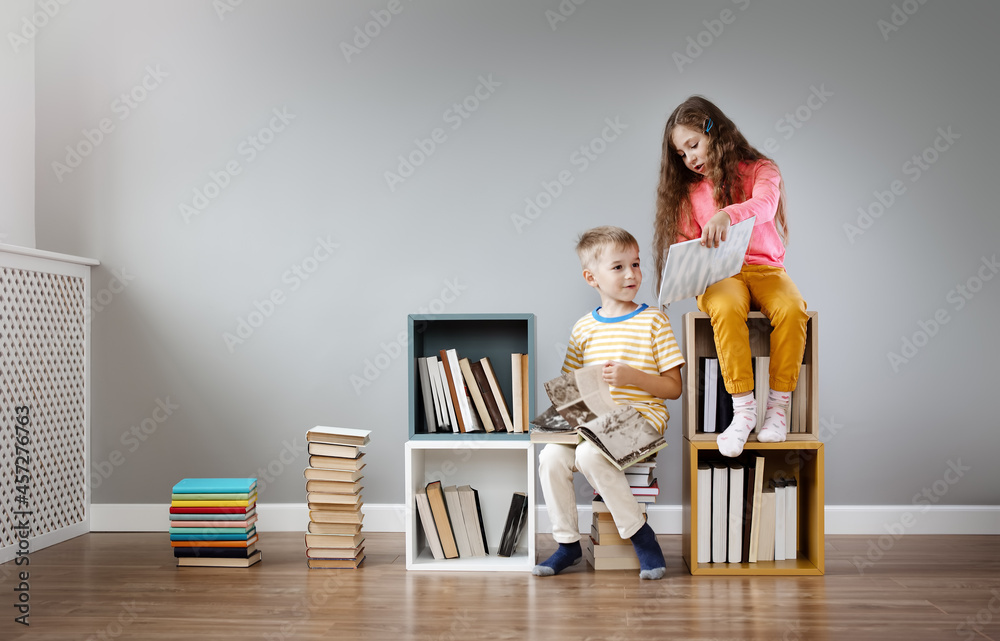 两个孩子坐在房间里看书