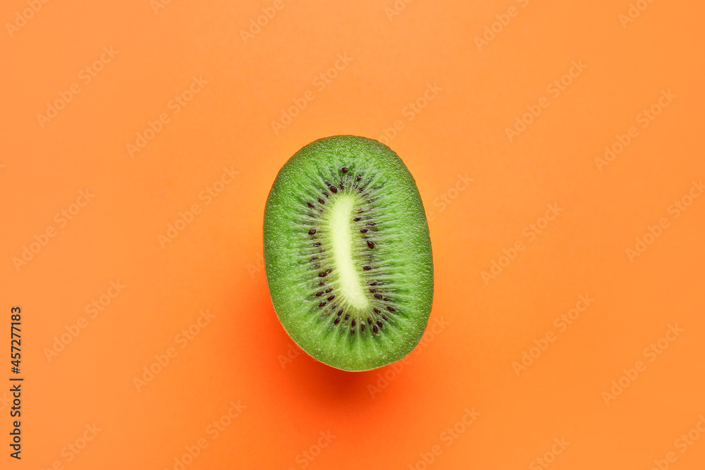 Piece of fresh kiwi fruit on color background