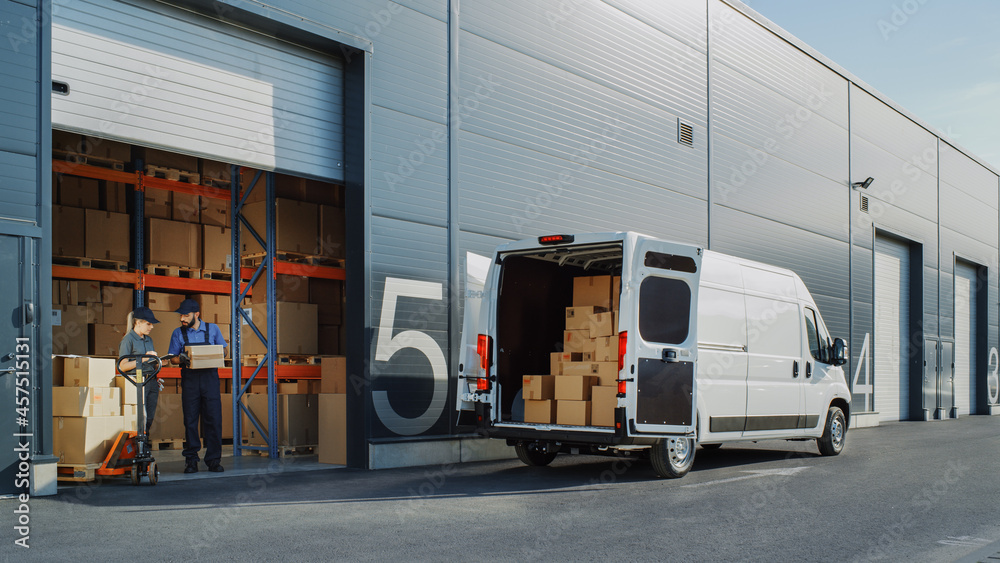 敞开大门的物流仓库外，装有纸板箱的送货车。卡车运输