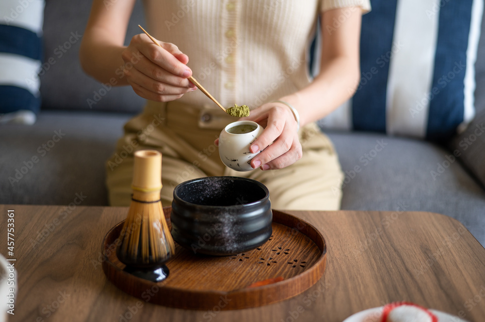 女性在家用茶道套装制作抹茶绿茶饮料