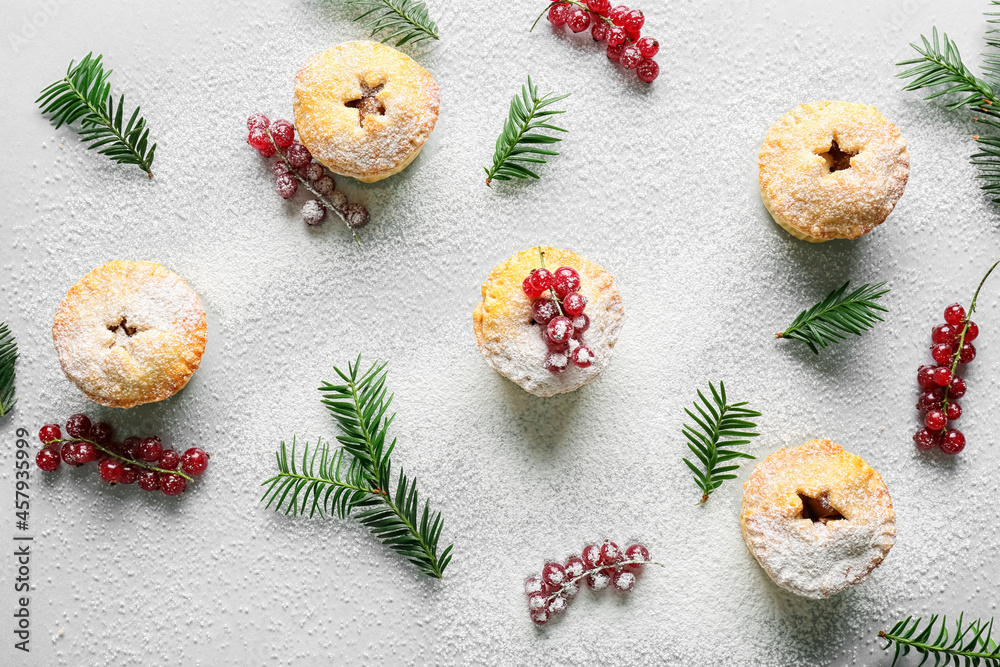 Composition with Christmas mince pies, cranberry and fir branches on light background