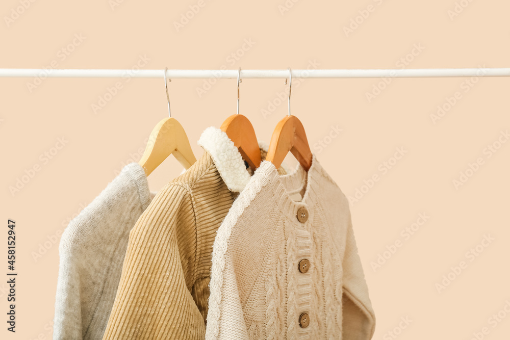 时尚的婴儿衣服挂在衣架上，背景为彩色