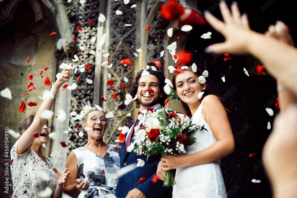 一家人向新婚新娘和新郎扔玫瑰花瓣