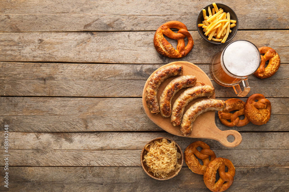 一杯冷啤酒，木板上有巴伐利亚香肠和木制背景的小吃。啤酒节名人