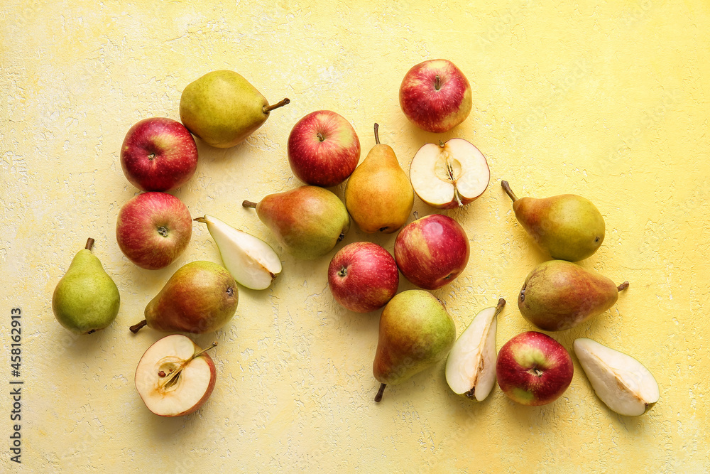 在彩色背景上成熟的梨和苹果