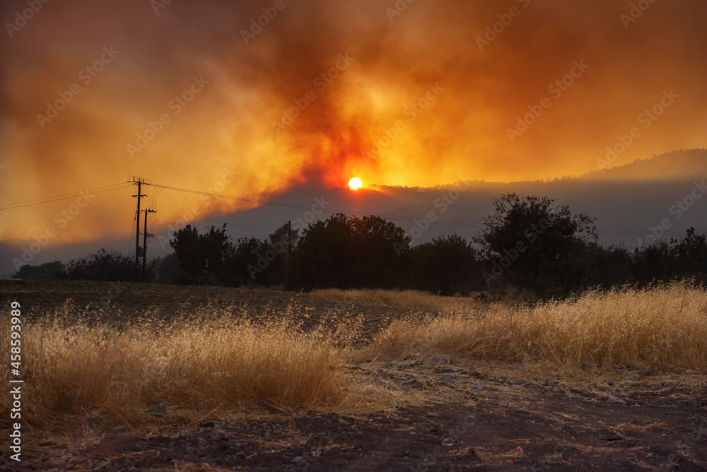 日落时的塞浦路斯乡村景观，背景是农田和戏剧性的野火