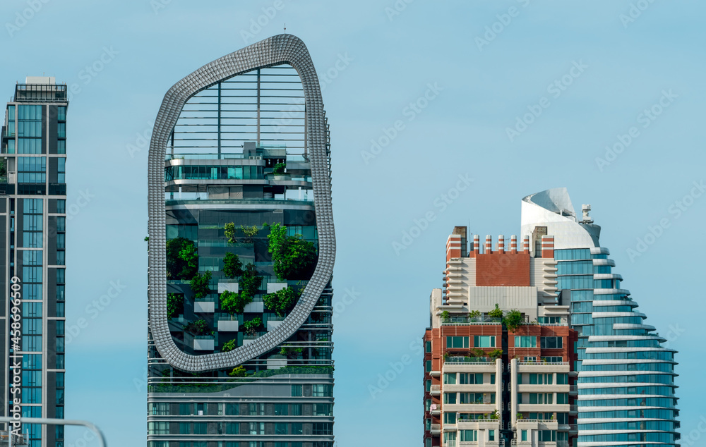现代城市中的环保建筑。可持续玻璃建筑上垂直花园中的绿树