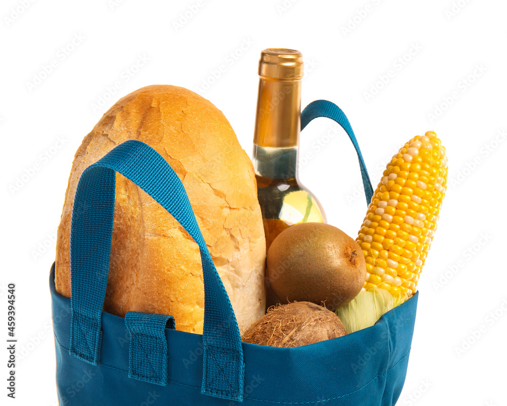 Eco bag with different products and bottle of wine on white background, closeup