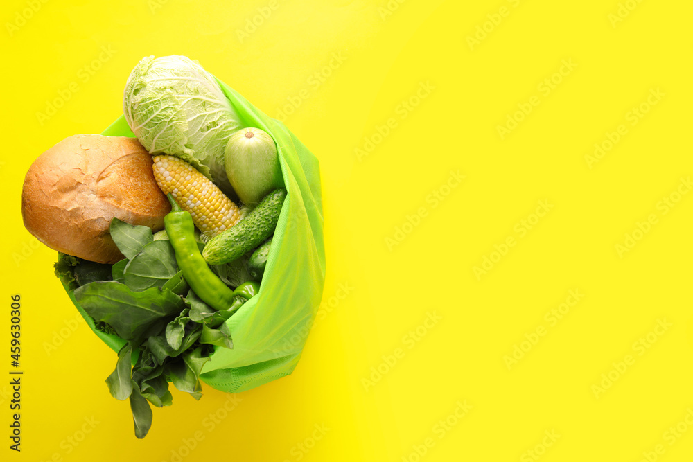 以蔬菜、绿色蔬菜和面包为背景的环保袋