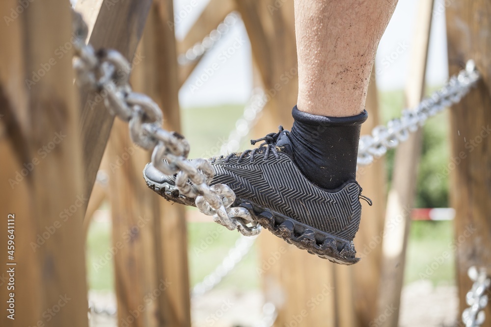 一名运动员穿着运动鞋在充满挑战的土跑道上的特写镜头。越野跑