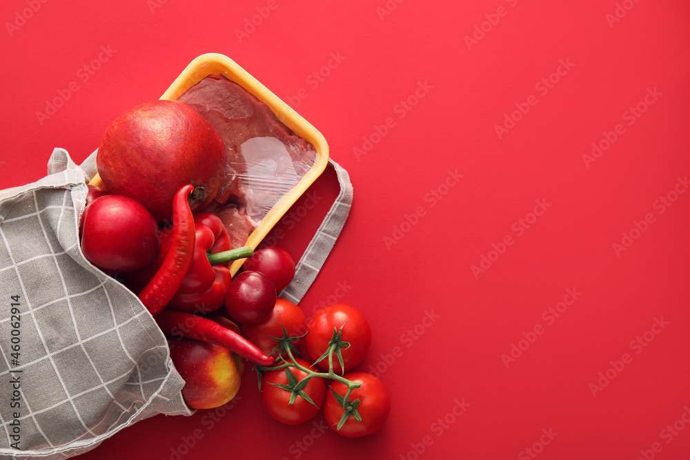 Eco bag with fruits, vegetables and meat on color background, closeup