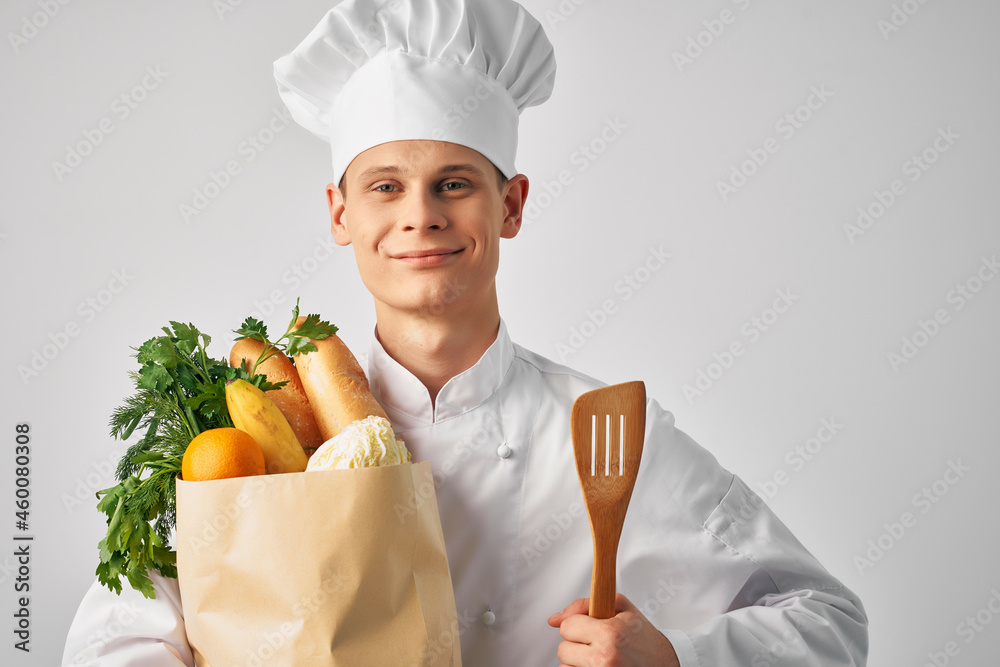 快乐的男厨师，带着一包健康食品提供厨房服务