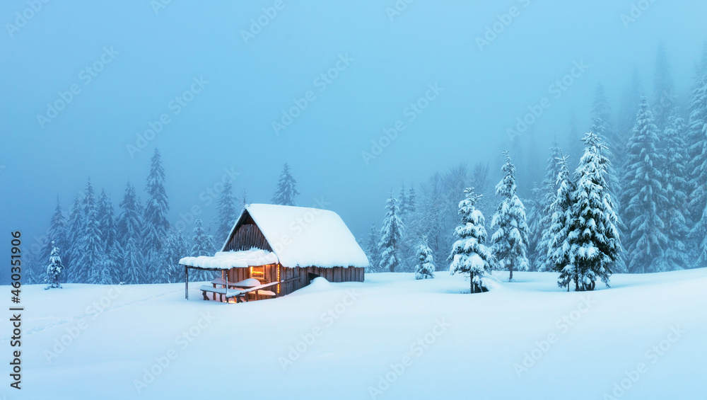 迷人的冬季景观，雪林中的木屋闪闪发光。喀尔巴阡山脉的舒适小屋