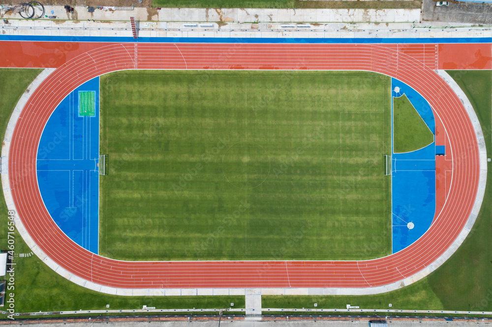Aerial view of empty new soccer field from above with running tracks around it Amazing new small sta