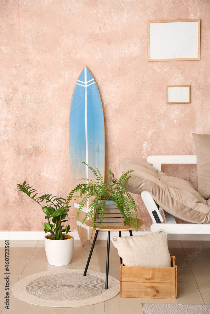 Interior of modern stylish room with surfboard, houseplants and sofa