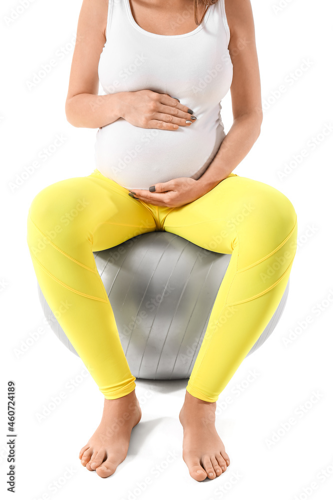 年轻孕妇用健身球在白色背景下做瑜伽，特写