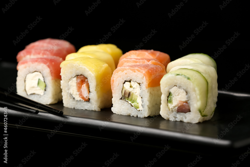 深色背景下有美味寿司卷的盘子