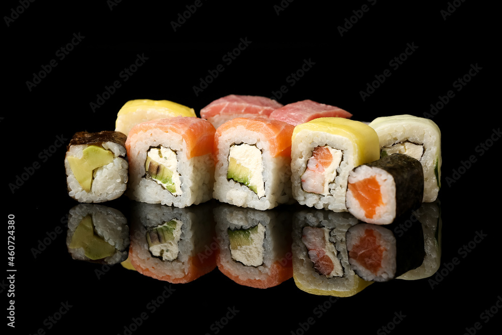 Set of different sushi and maki rolls on dark background