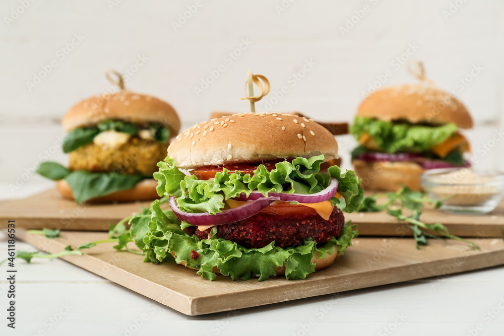Wooden boards with tasty vegetarian burgers on table