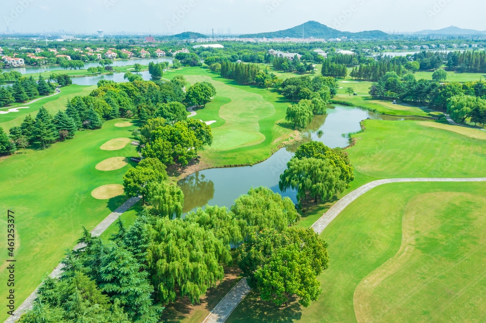 高尔夫球场上绿色草坪和森林的鸟瞰图。
