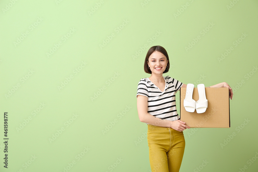 年轻女人，带着衣柜盒子和彩色背景的鞋子