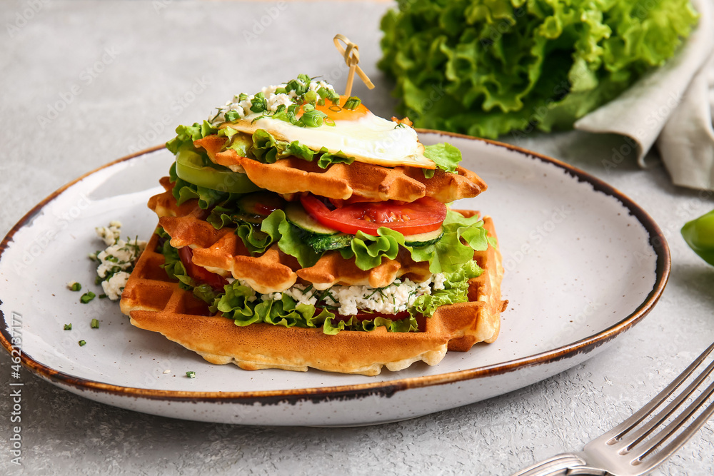 Tasty Belgian waffles with vegetables in plate on light background, closeup