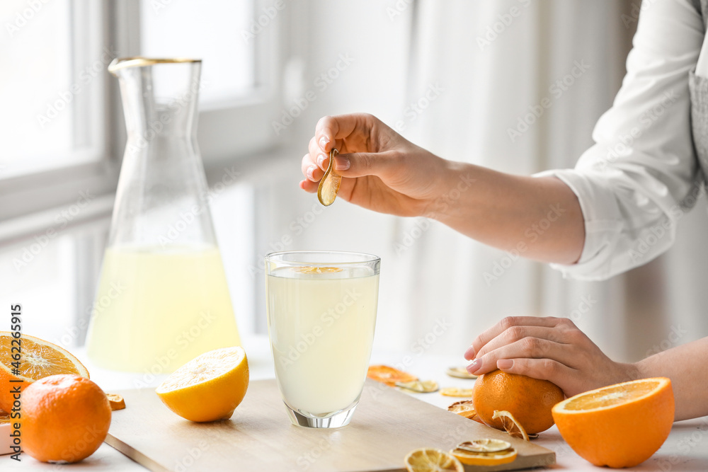 女人在厨房的餐桌上制作新鲜柑橘汁