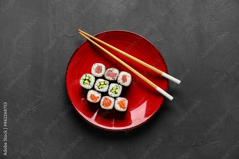 深色背景下有美味的maki卷和木筷子的盘子