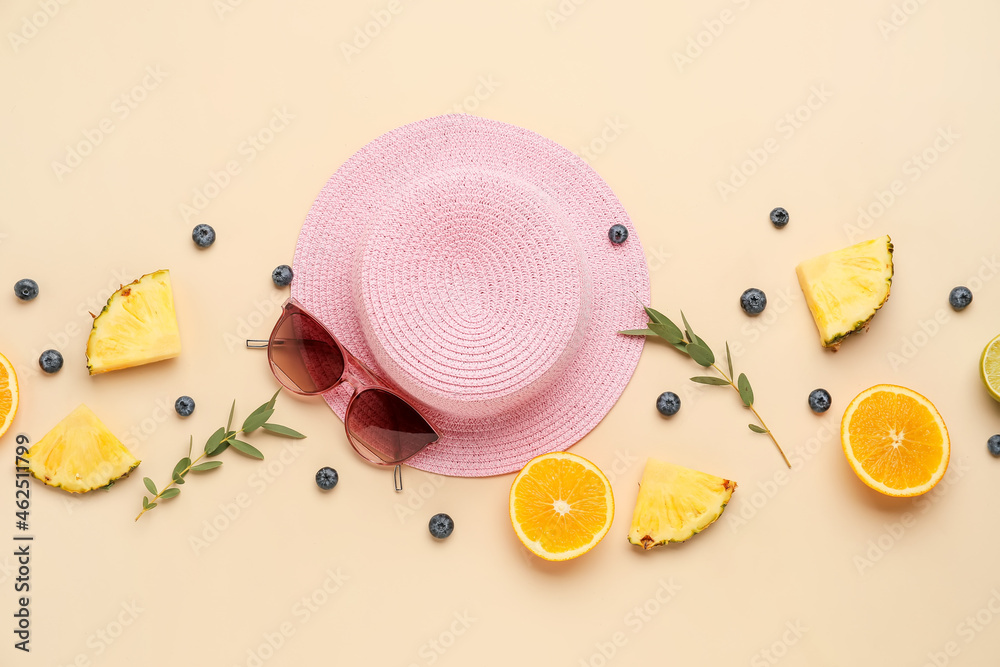 在彩色背景上搭配时尚的帽子、太阳镜和水果