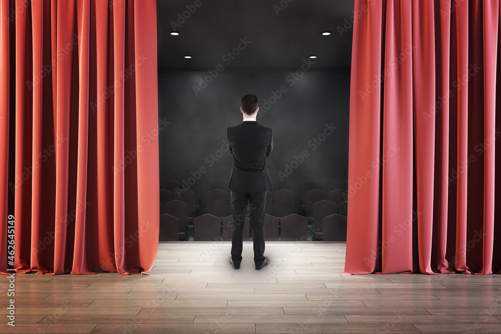 商人从红窗帘后面看舞台的背影。娱乐、表演和公关