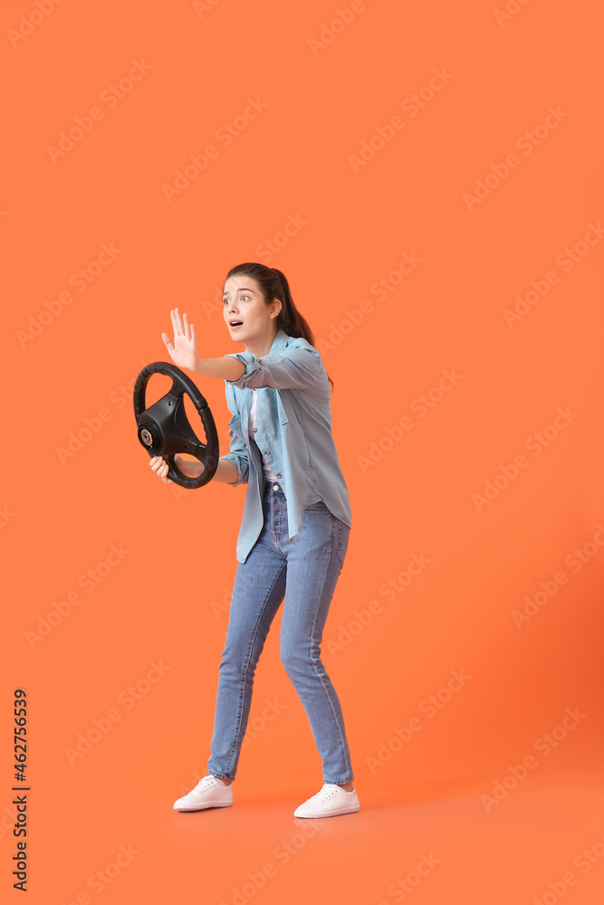 带方向盘的年轻女子在彩色背景上显示停止手势