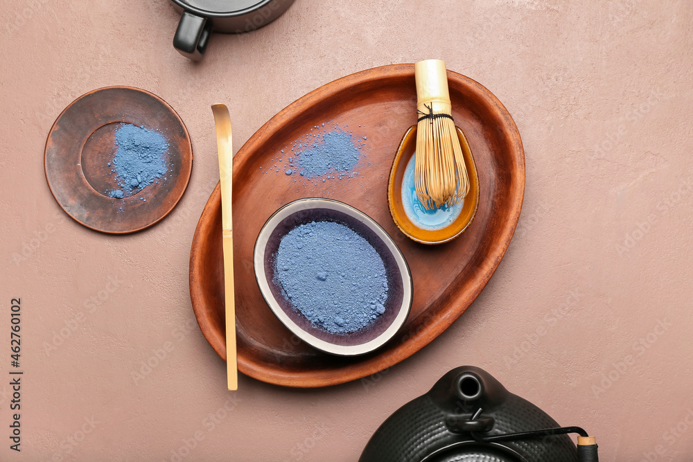 Tray with blue matcha tea, chasen and chashaku on color background