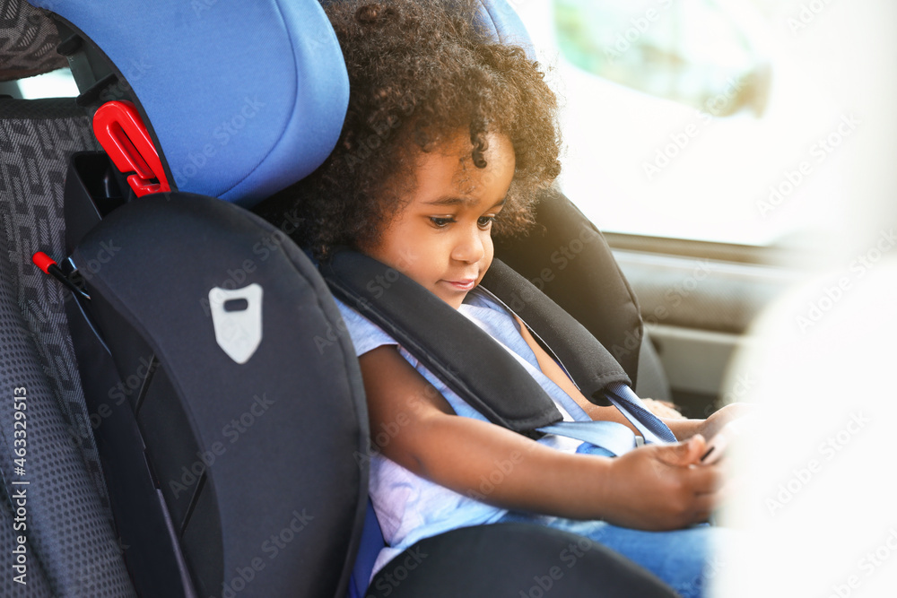 非洲裔小女孩拿着手机在汽车安全座椅上看动画片