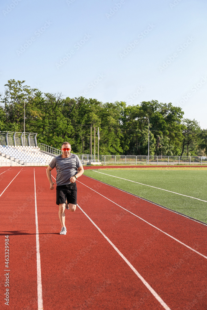 运动型成熟男子在体育场奔跑