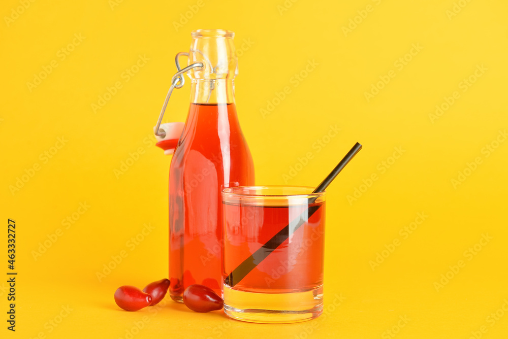 彩色背景的健康山茱萸饮料玻璃杯和瓶子