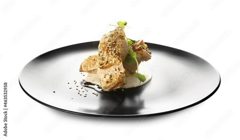 Plate with baked cod fillet, greens and sauce on white background