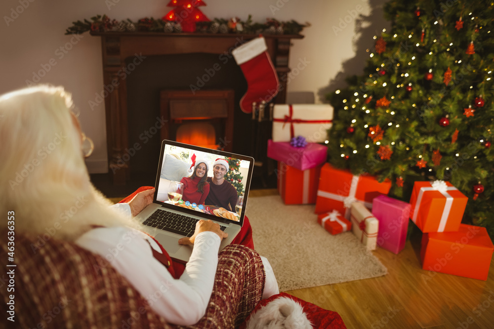 高加索圣诞老人在圣诞笔记本电脑上与高加索夫妇视频通话