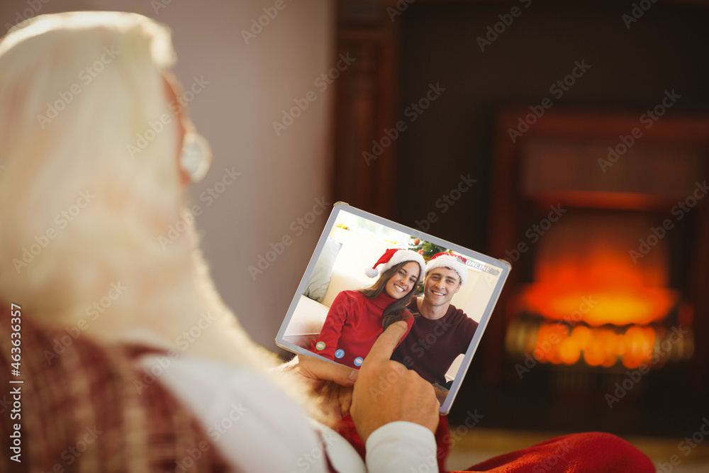 高加索圣诞老人在圣诞笔记本电脑上与高加索夫妇视频通话