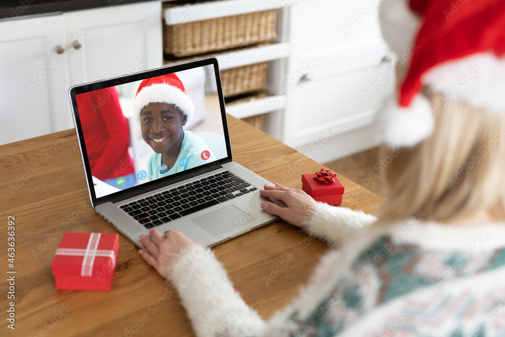 圣诞笔记本电脑上的白人女性与非裔美国男孩视频通话