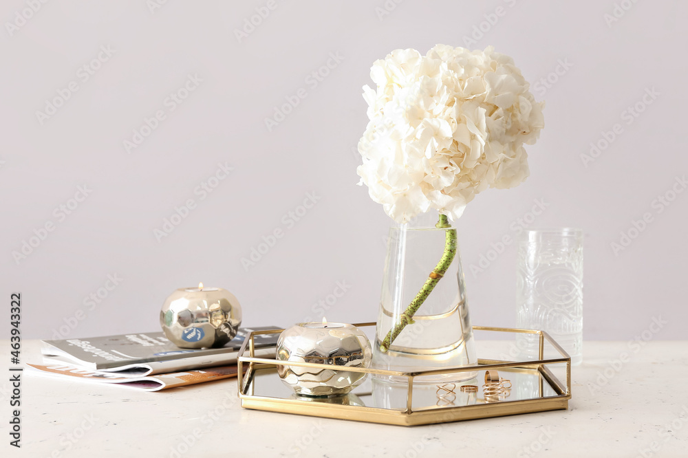 桌上有白色绣球花的玻璃花瓶，装饰时尚