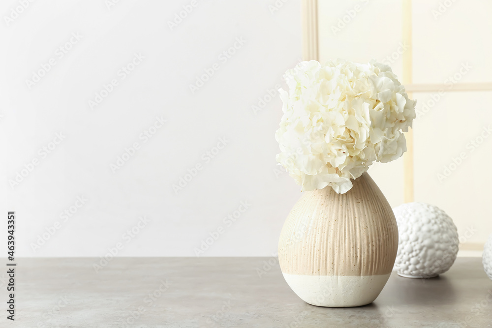 客厅内部桌子上摆放着时尚的花瓶，上面有美丽的绣球花