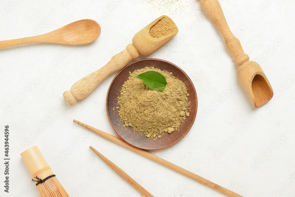 Plate and scoops with hojicha powder on white background