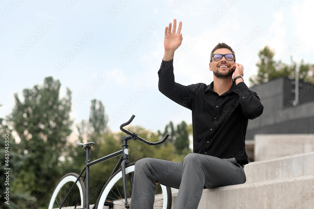 骑自行车的商人在城市街道上用手机聊天