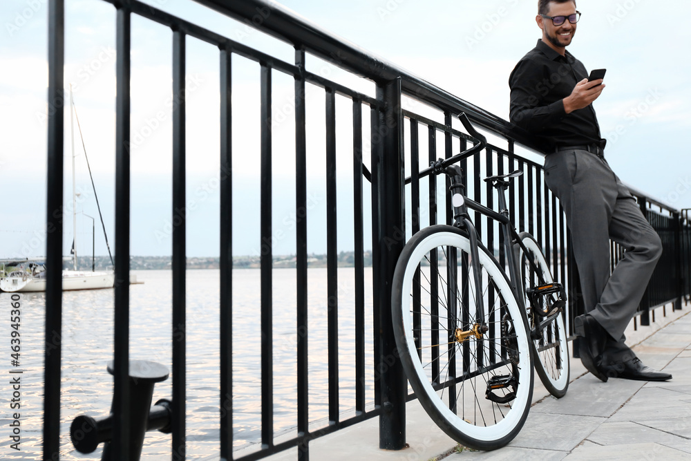 Businessman with bicycle on embankment