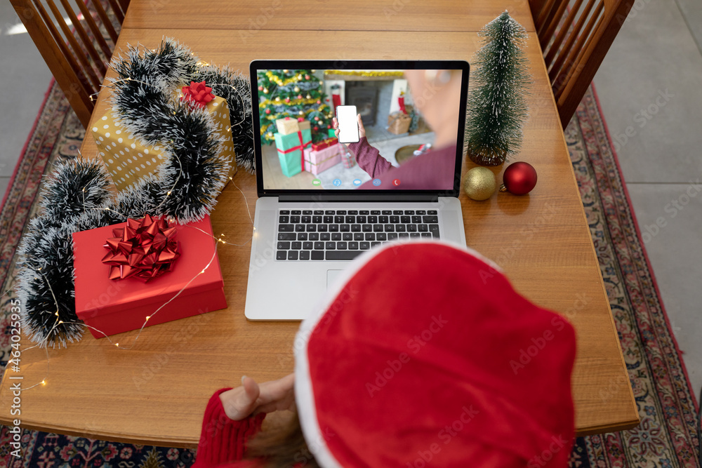 戴着圣诞帽的白人妇女在笔记本电脑上与朋友圣诞视频通话