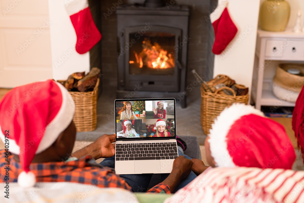 一对戴着圣诞老人帽的非裔美国人在圣诞节与朋友视频通话