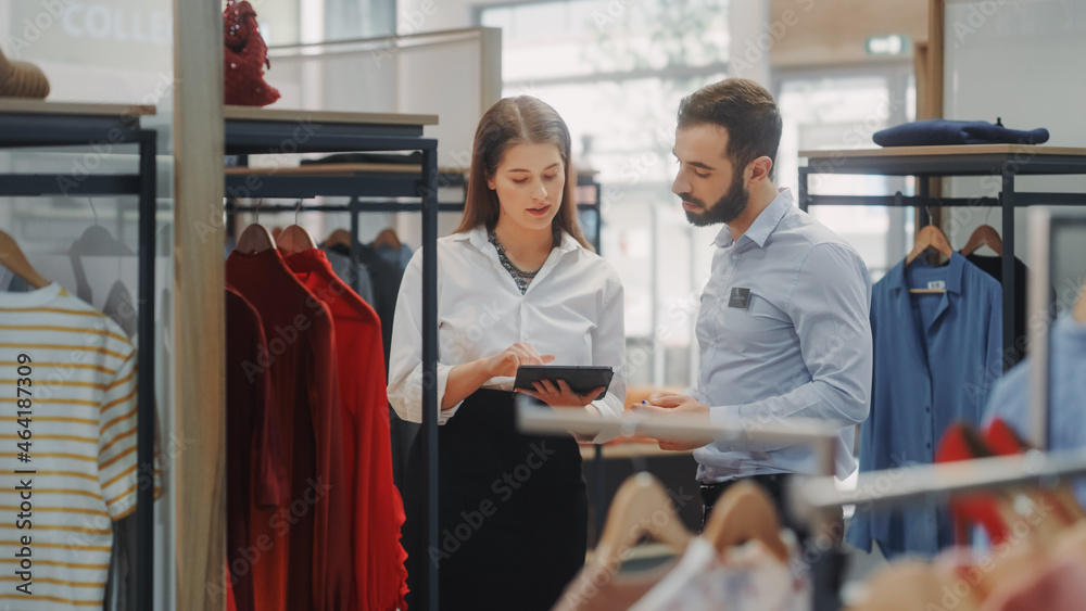服装店：女商人使用平板电脑，与Collab视觉营销专家交谈