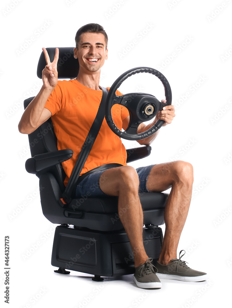 坐在汽车座椅上，方向盘在白底上显示胜利手势的男子